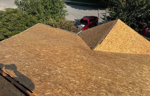 Bare roof deck after tear-off, every sheet exposed for inspection
