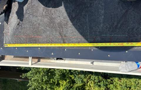 New drip edge along the eave, with a tape measure checking it