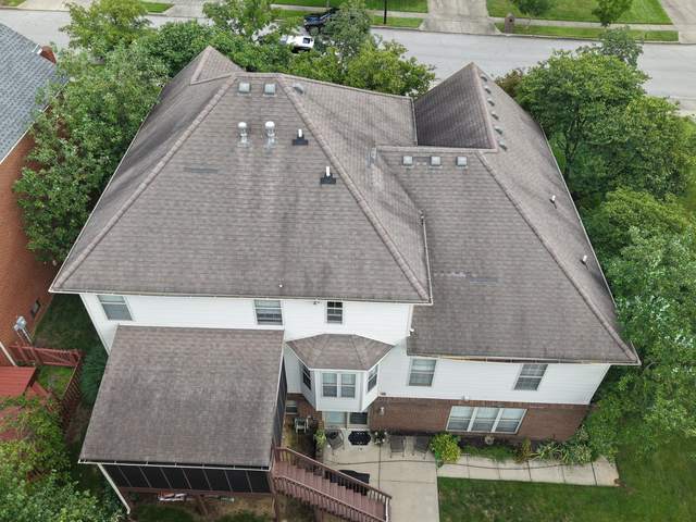 Before: large two-story hip roof with weathered brown shingles, seen from above the back